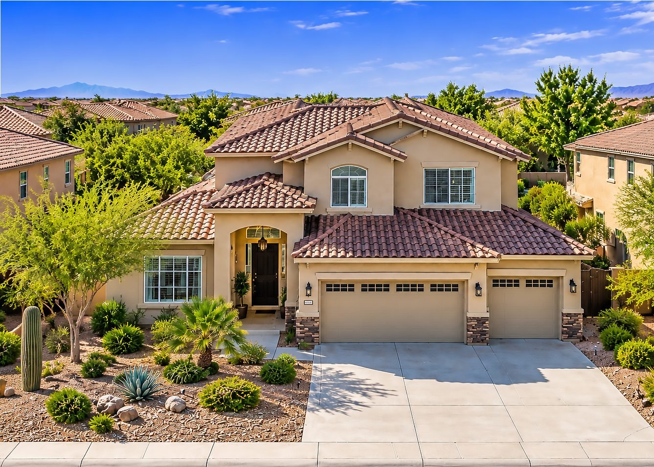 Two-story East Valley home with a tile roof and desert landscaping under a blue sky